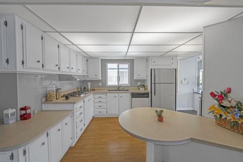 A kitchen with white cabinets and counter tops.