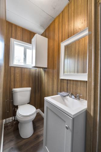 A bathroom with wood paneling and a toilet.