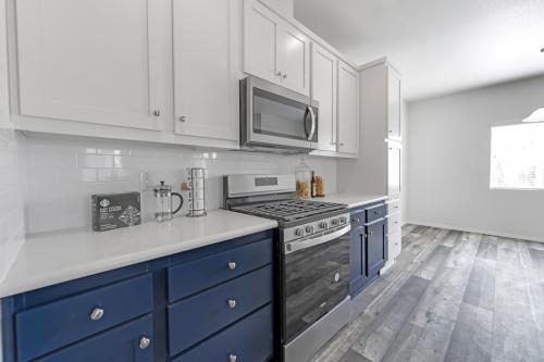 A kitchen with white cabinets and blue appliances.