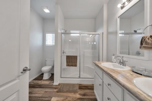 A white bathroom with wood floors and a shower.